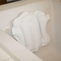 Bath pillow with suction cups attached inside a bathtub for added comfort and support during bathing