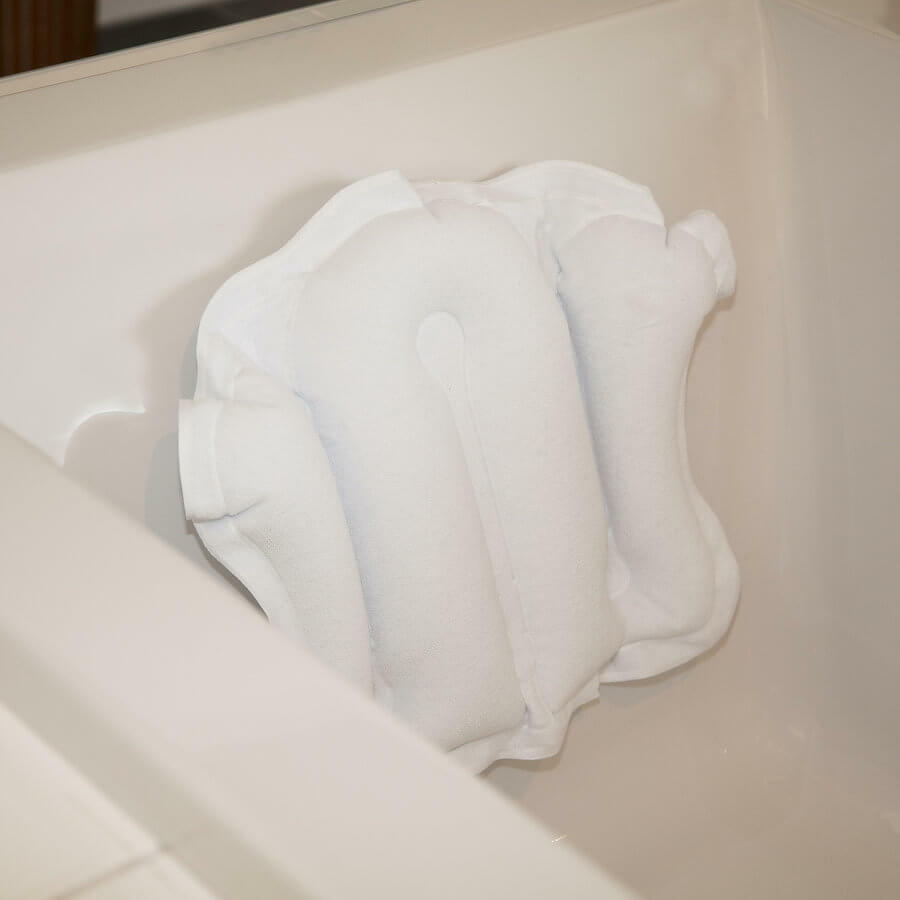 Bath pillow with suction cups attached inside a bathtub for added comfort and support during bathing