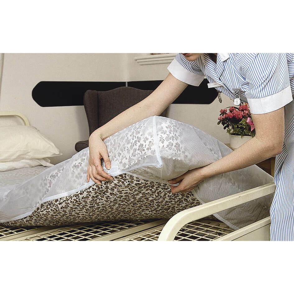 Waterproof bed protector fitted over a mattress in a hospital care setting